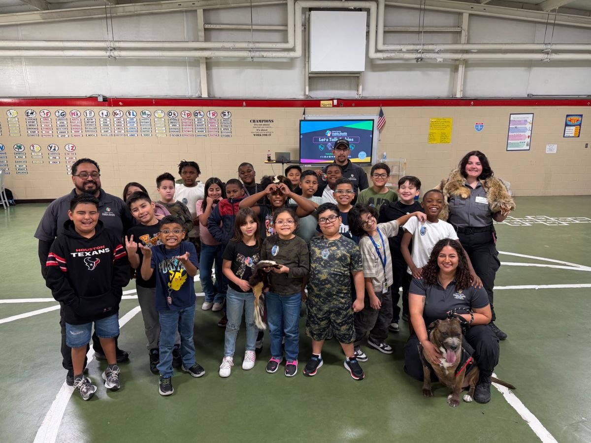 Students and Harris County Pets representatives participating in an animal safety activity