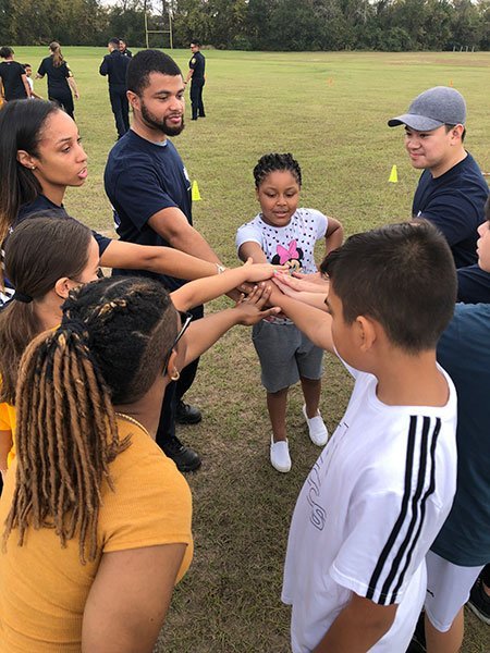Coach and kids huddled together on a field